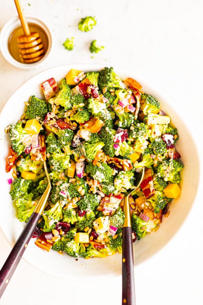 Classic broccoli salad in a bowl with utensils. 