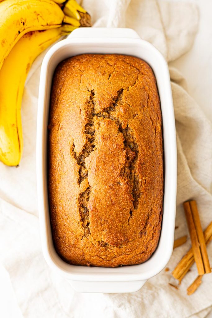 A freshly baked loaf of healthy banana bread in a bread loaf pan.
