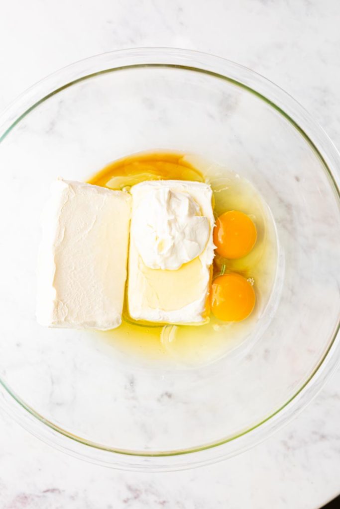 Mini cheesecake batter ingredients in a glass bowl.