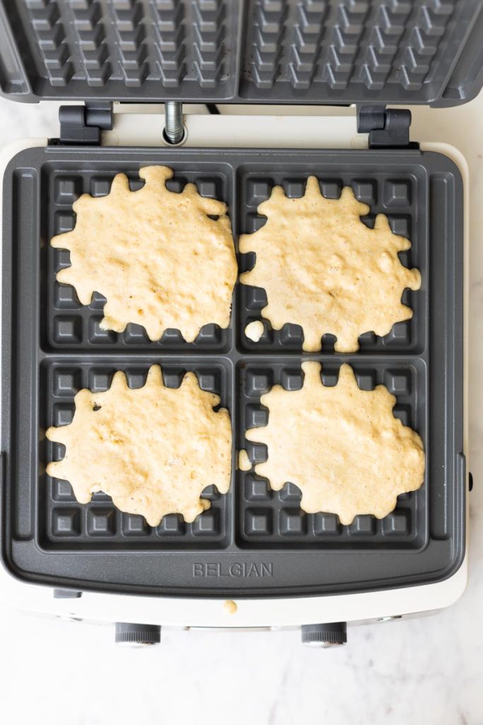 Fluffy whole wheat waffle batter in a waffle maker.