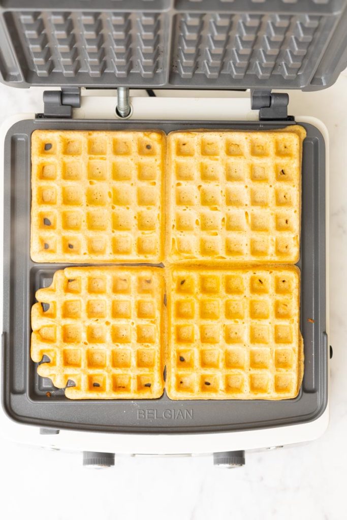 Cooked fluffy whole what waffles in a waffle maker.